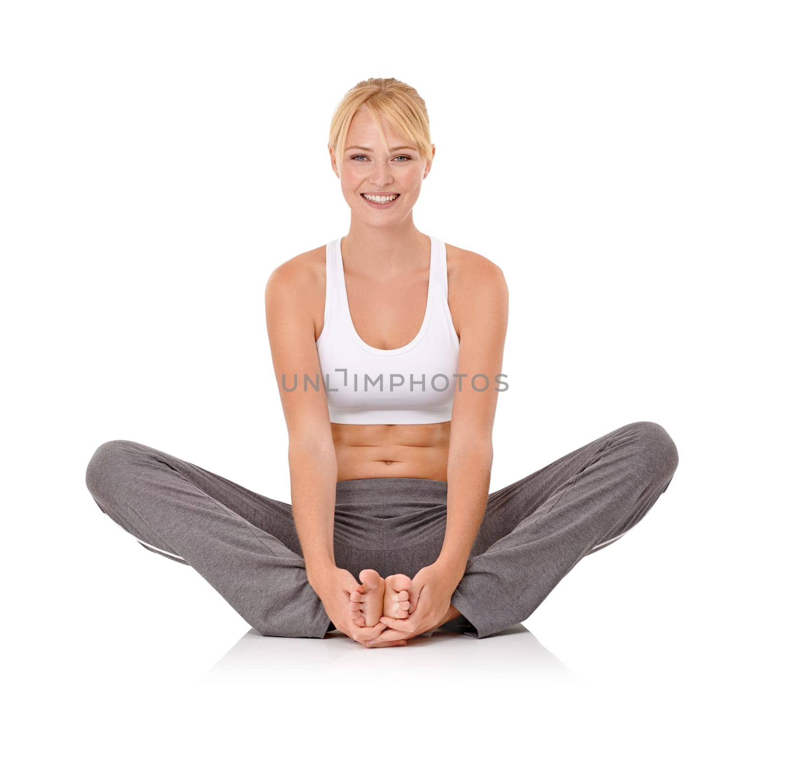 Shes stretching before her next workout. Portrait of an attractive young woman stretching against a white background