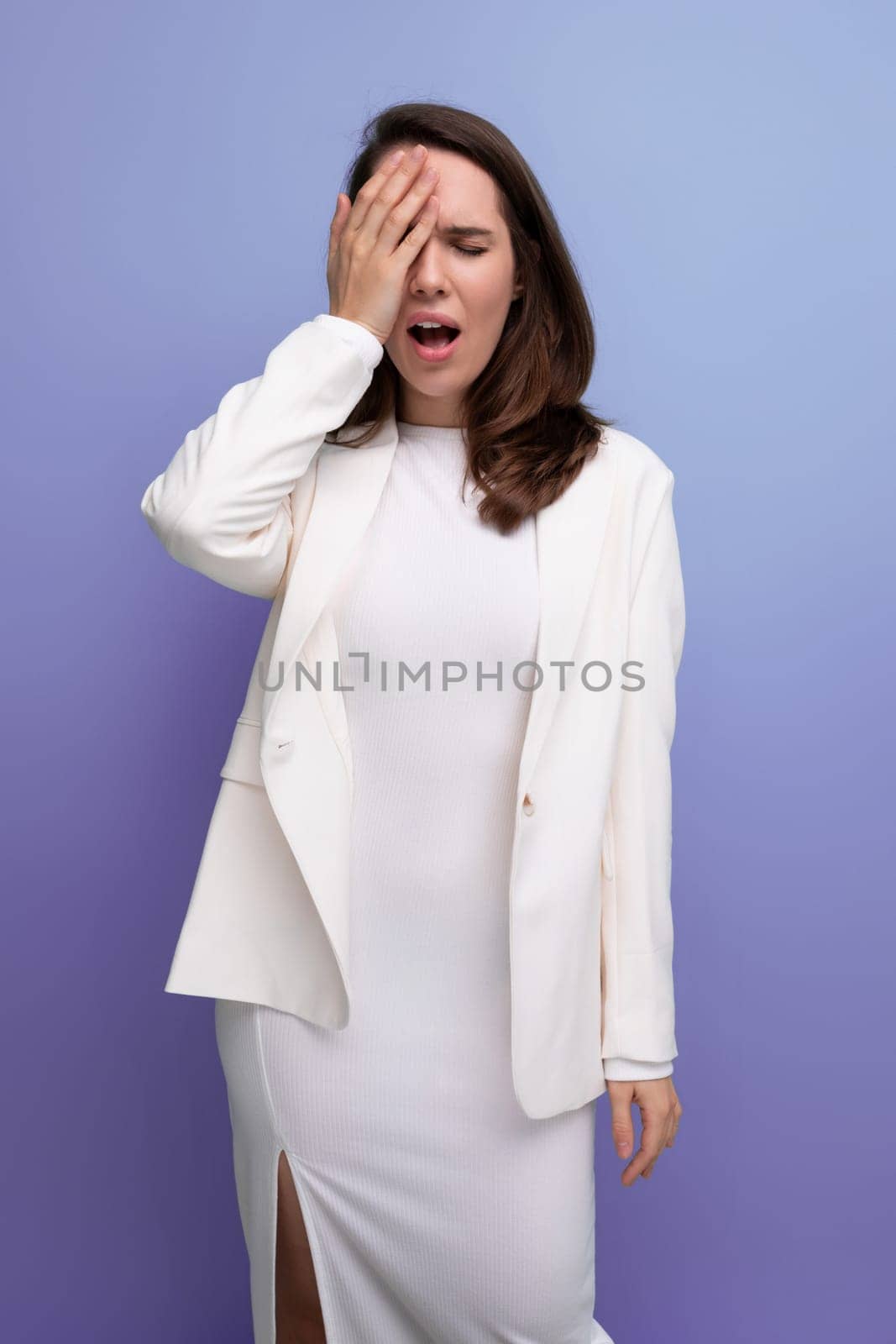 upset sad brunette young woman in a dress and jacket with a grimace.