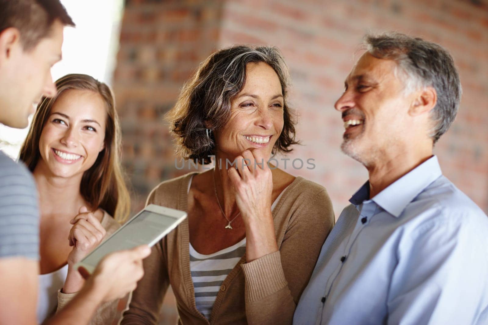 Riding the good news high. Shot of a happy family having a discussion. by YuriArcurs