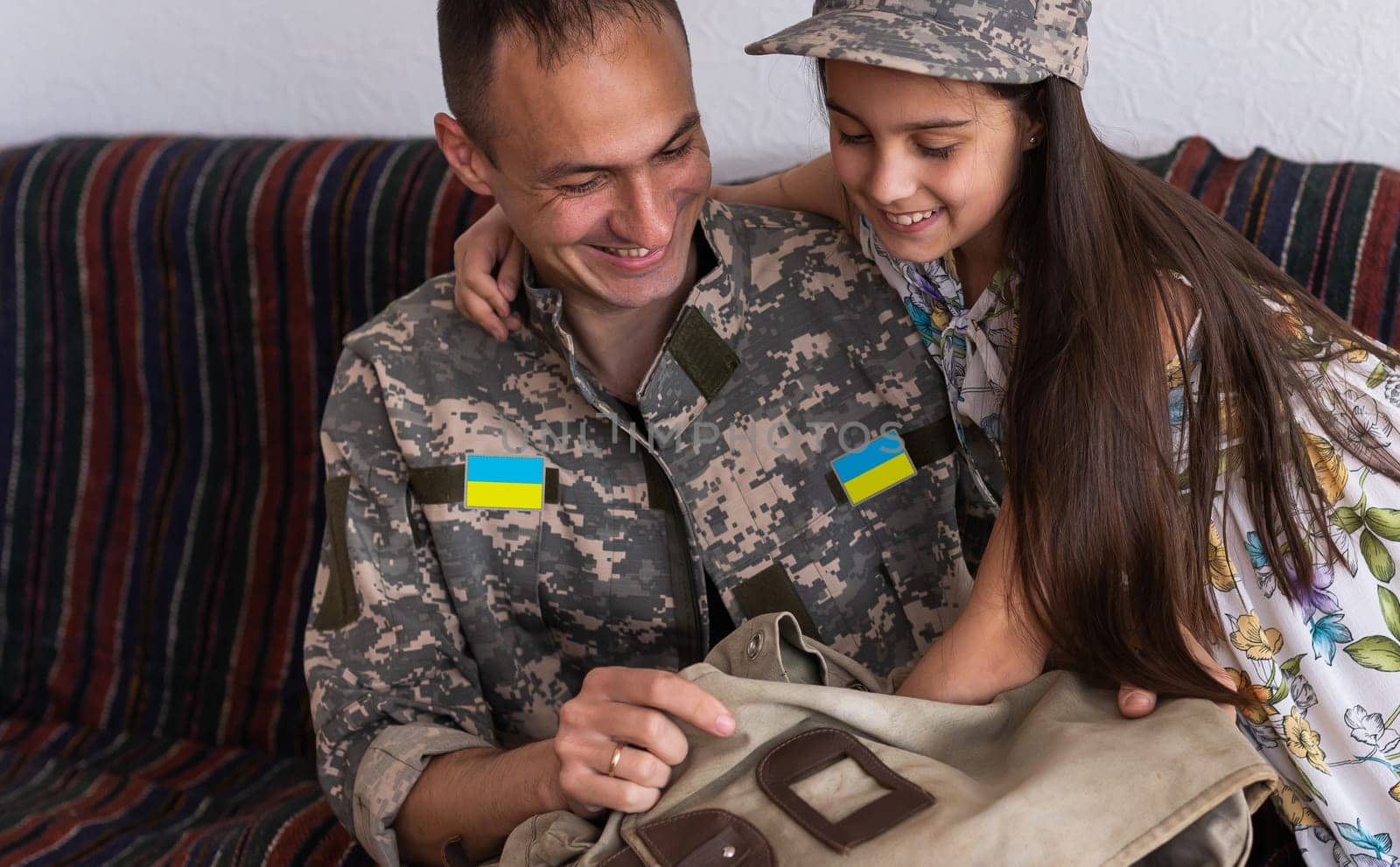 Father in Ukrainian military uniform and his daughter. Family reunion.