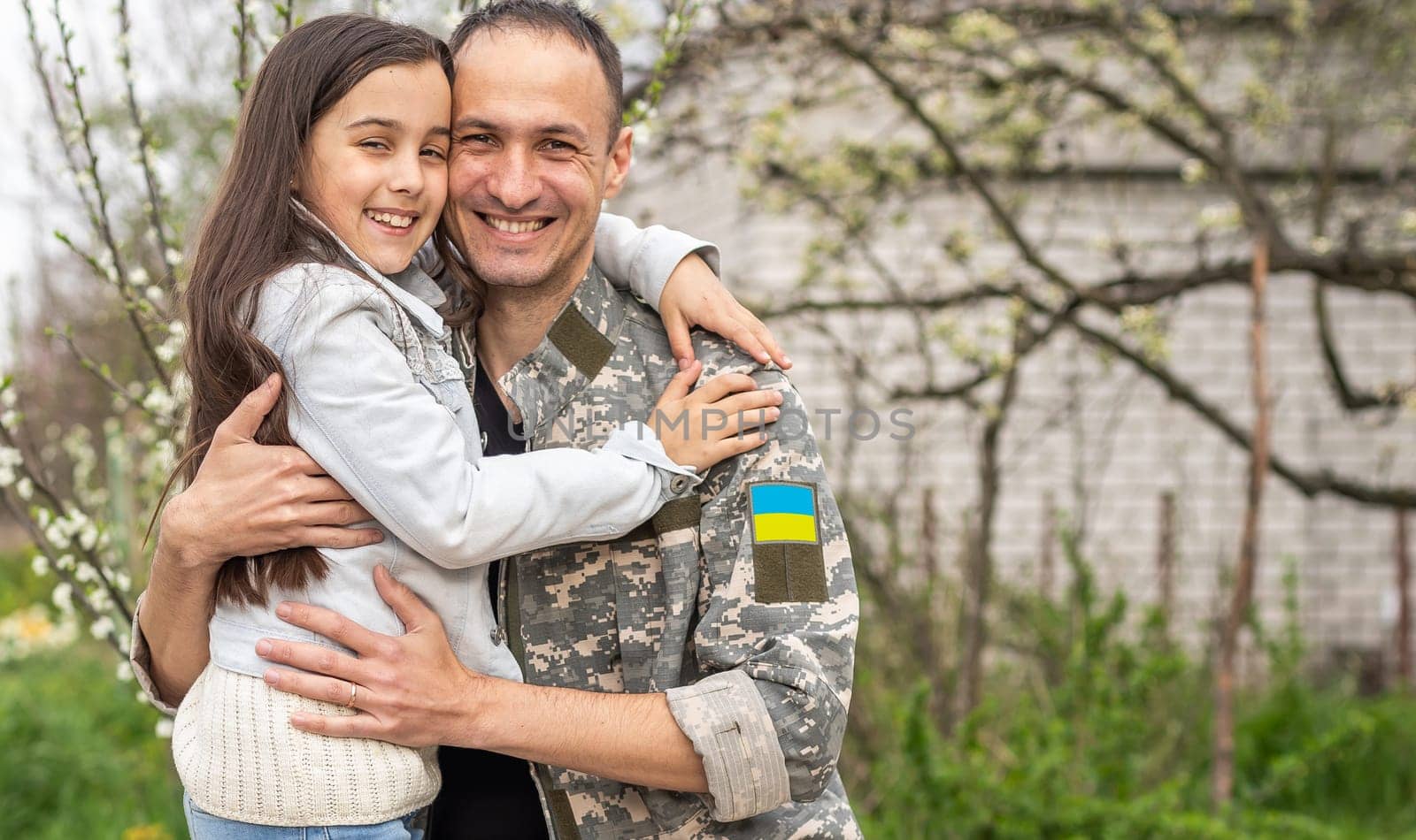 Father in Ukrainian military uniform and his daughter. Family reunion.