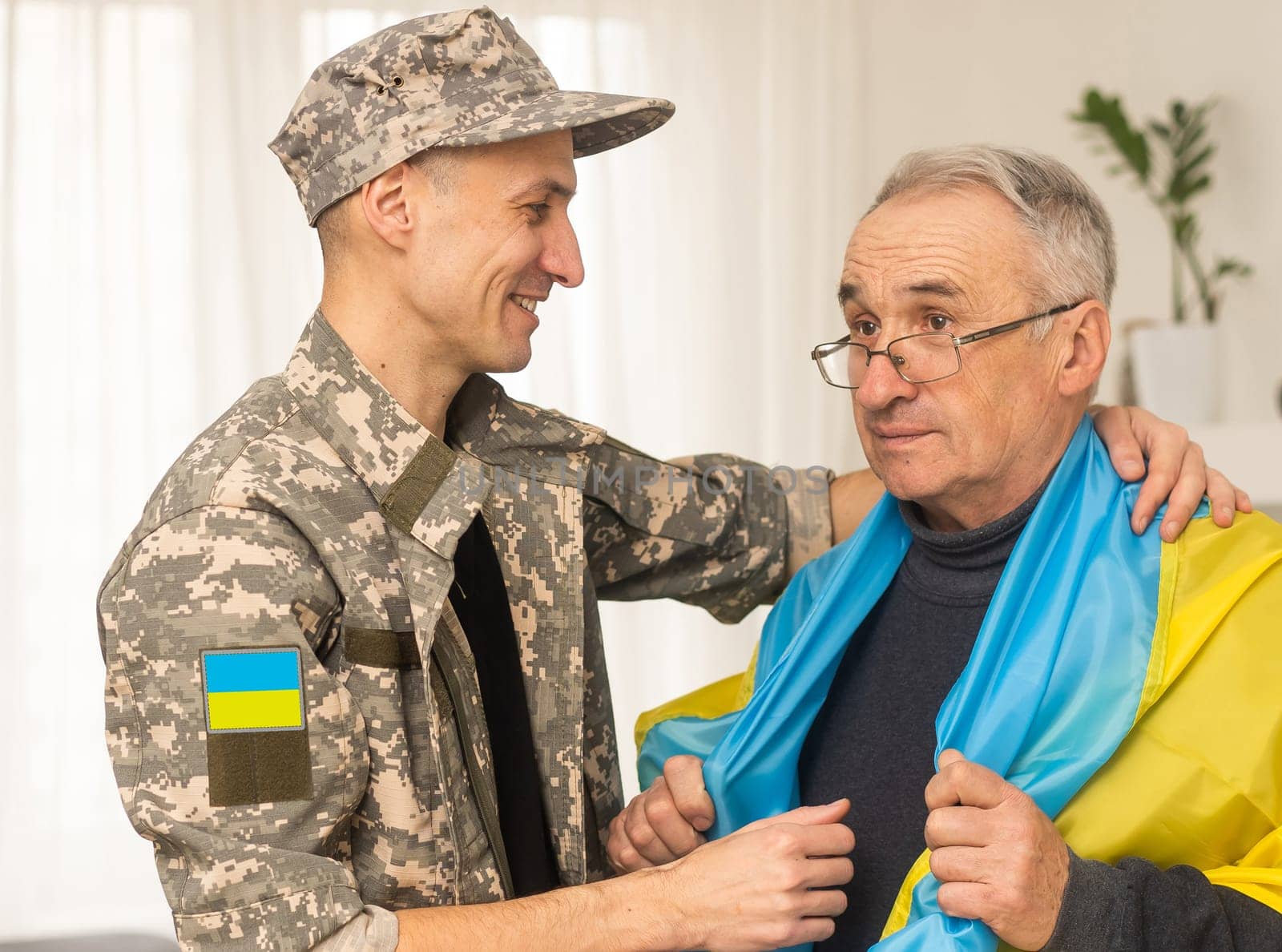 Soldier in military uniform reunited with his family and Ukrainian flag.