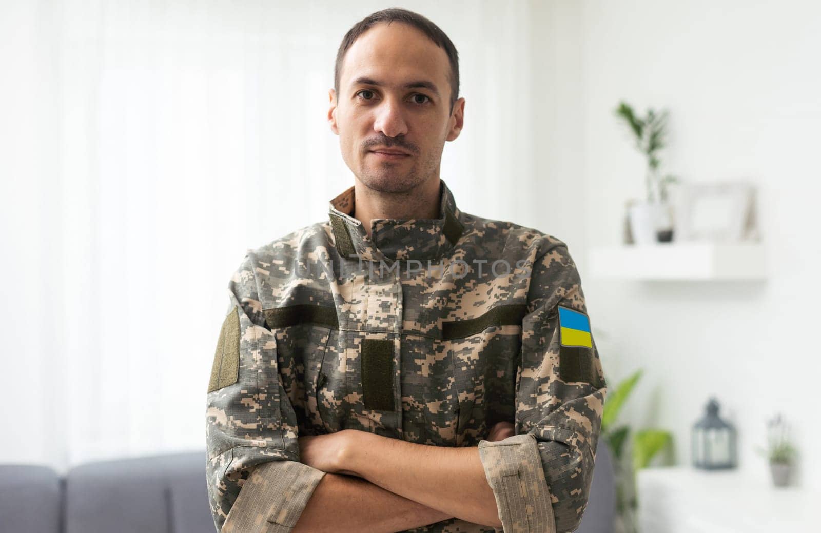 A Ukrainian military man holds the national flag in his hands as a symbol of strong. War in Ukraine