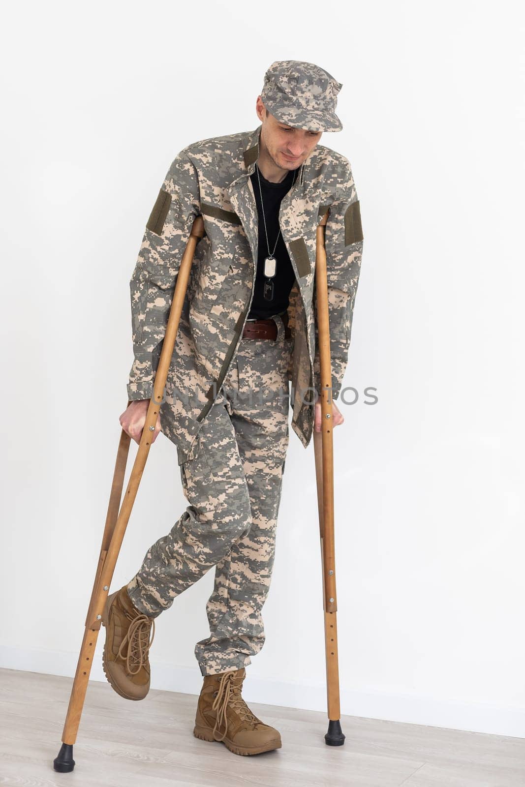 Portrait of soldier with crutches against white background by Andelov13