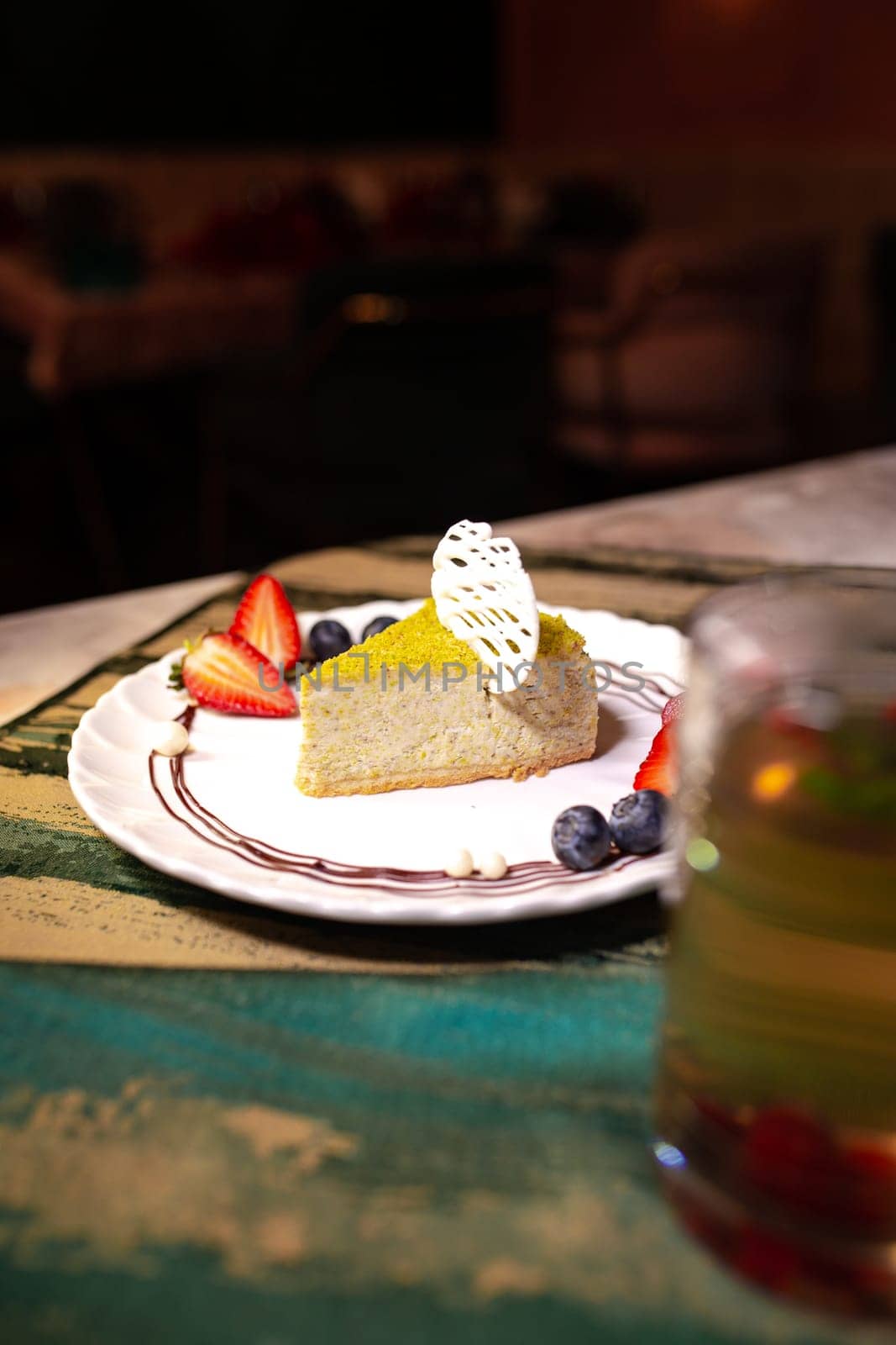 pistachio cheesecake with berries on a plate in a restaurant by Pukhovskiy