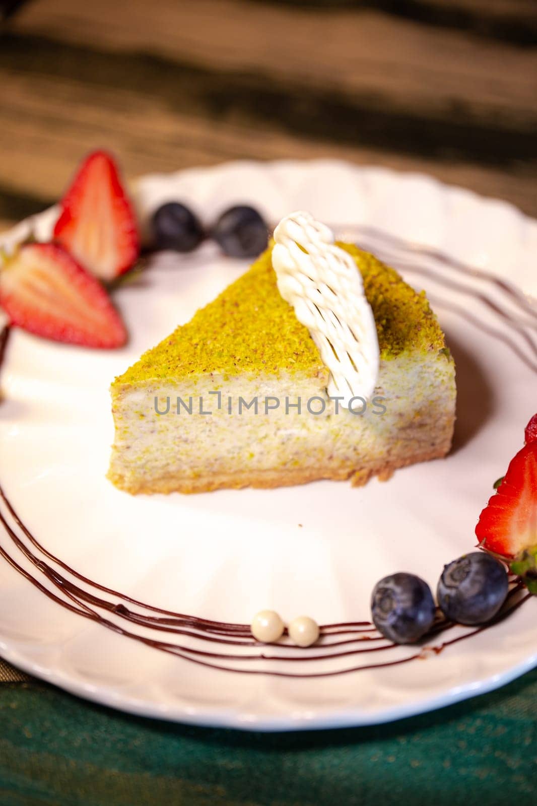 pistachio cheesecake with berries on a plate in a restaurant.