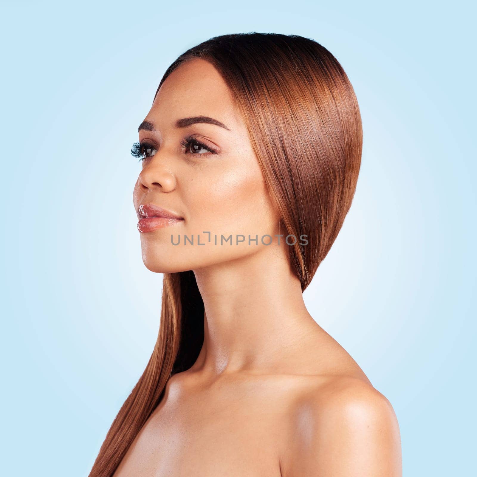 Face, skincare and hair care of woman in studio isolated on a blue background. Hairstyle cosmetics, thinking and aesthetics of young female model with salon treatment for growth, texture and balayage.