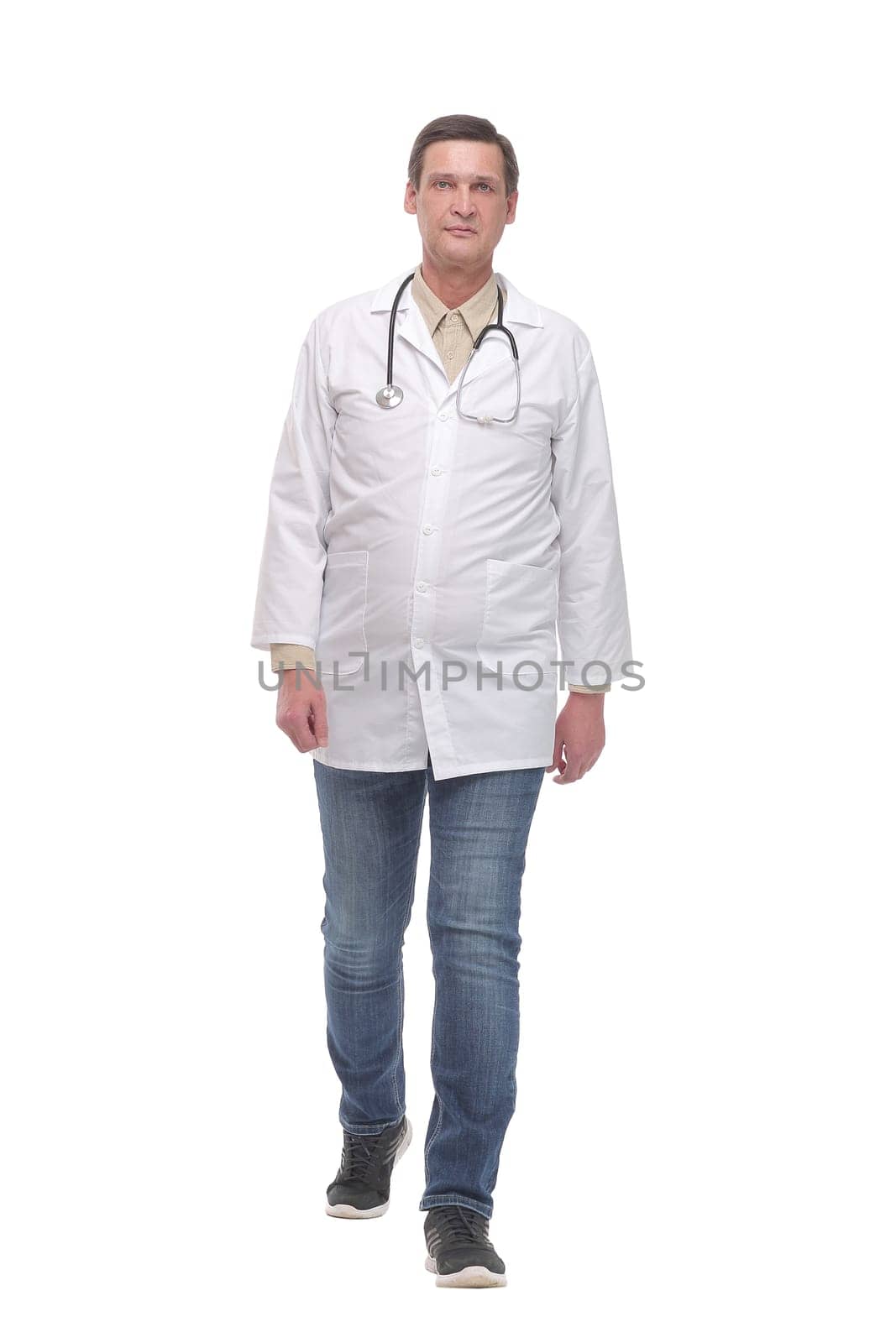 Full length portrait of young caucasian with stethoscope walking doctor isolated on white
