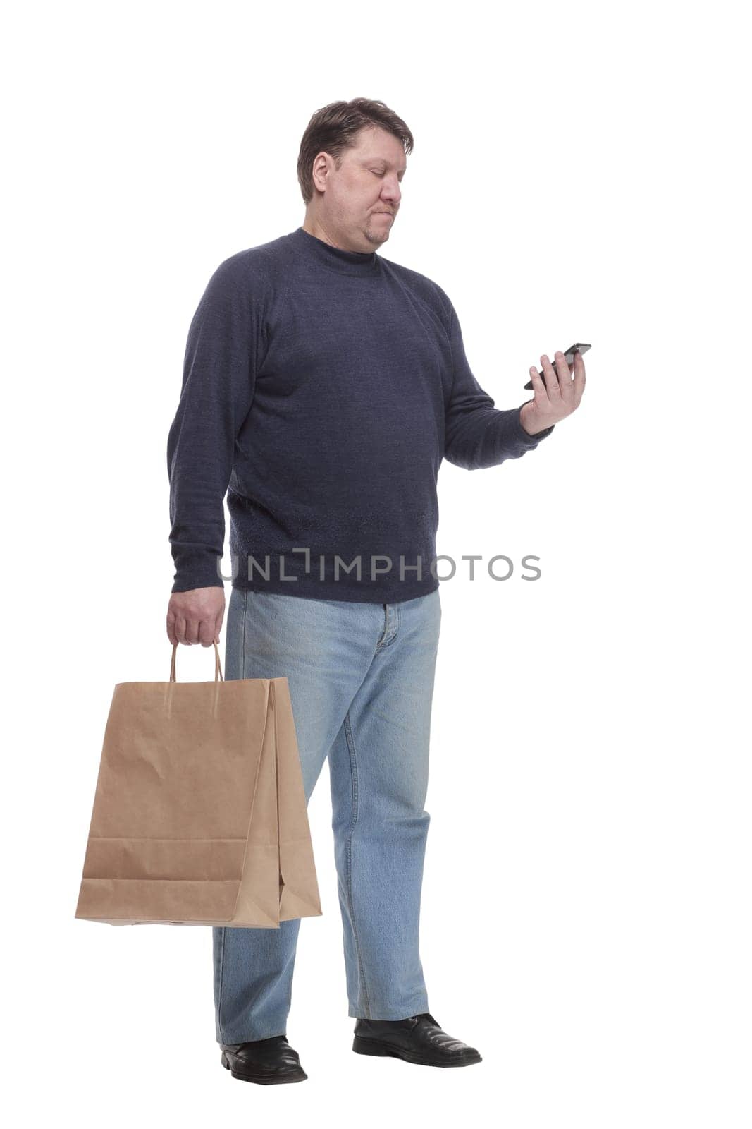 in full growth. casual man with a smartphone .isolated on a white background.