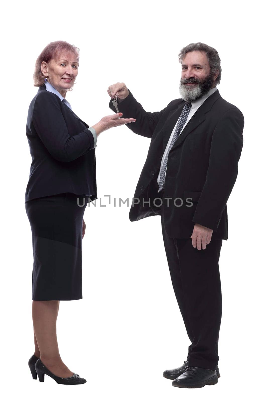 in full growth. businessman handing keys to a business lady . isolated on a white background