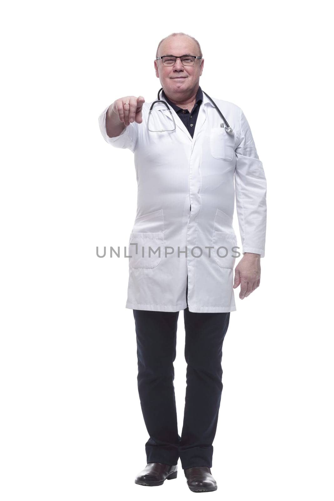 in full growth. smiling doctor pointing at you. isolated on a white background