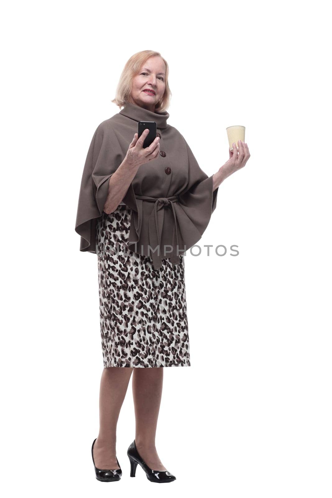 attractive mature woman with smartphone and coffee to take away. isolated on a white background.