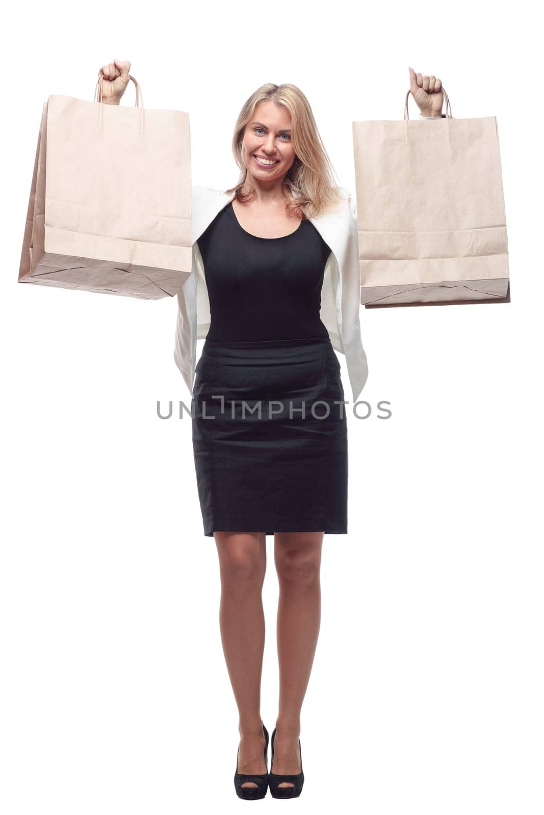 in full growth. happy business woman showing shopping bags. isolated on a white background.