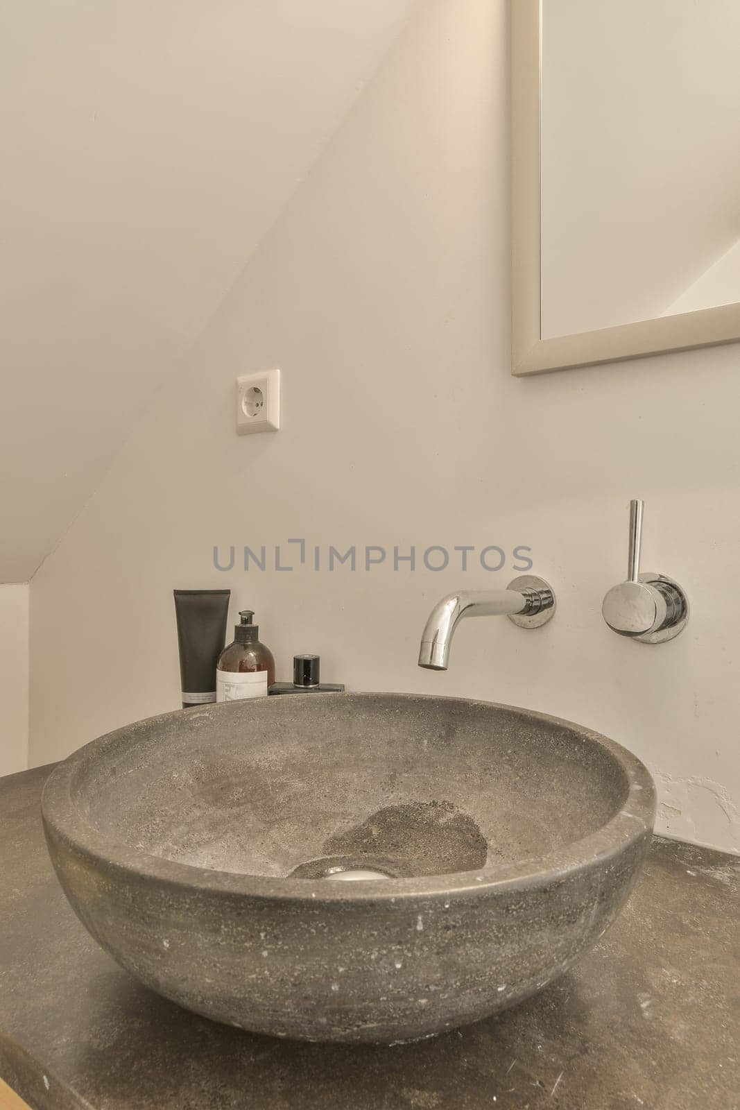 a concrete sink in a bathroom with a fauc by casamedia