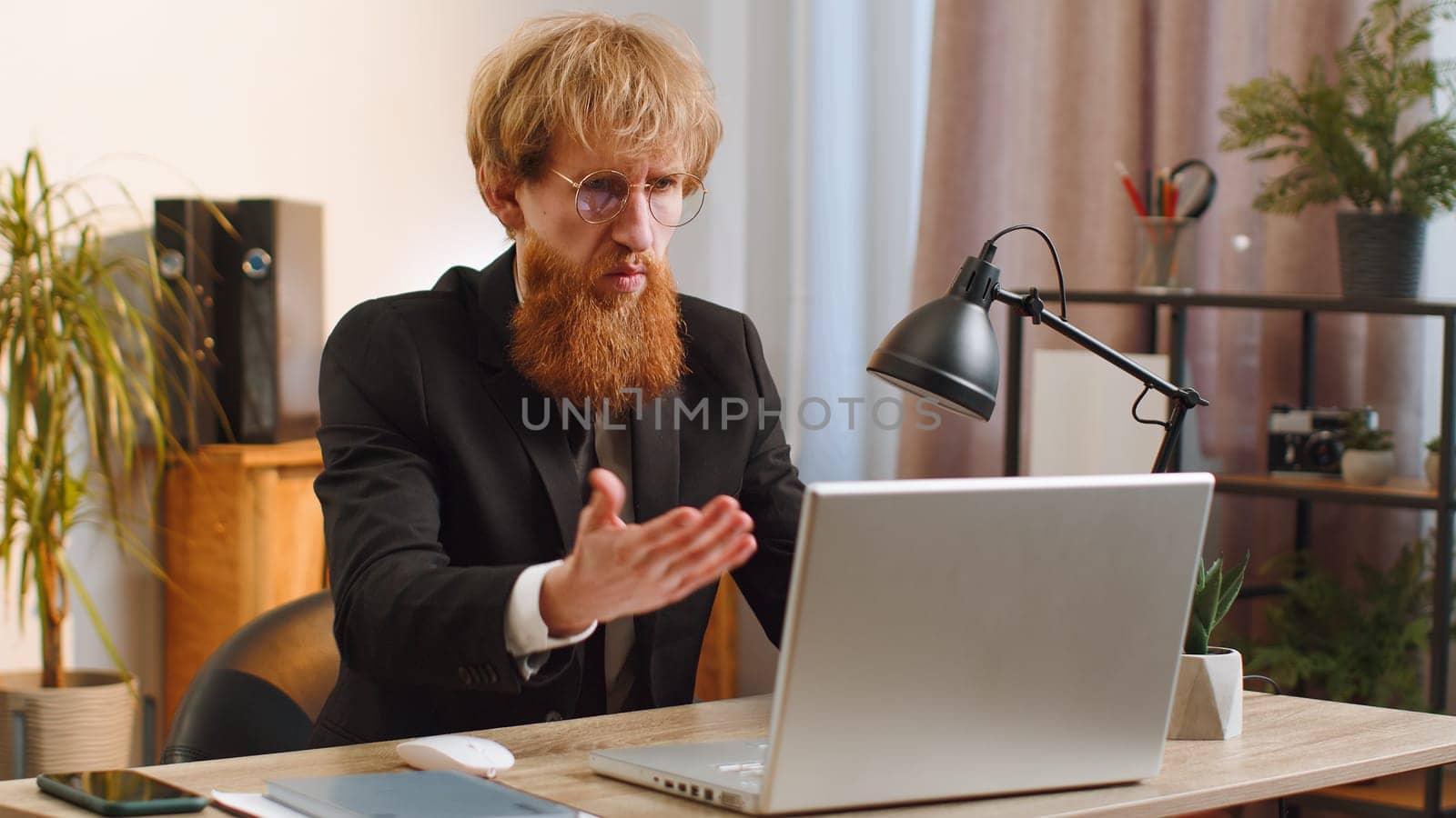 Irritated shocked business man while working on laptop, unexpected online website problem, computer virus data loss by hacking. Manager freelancer feeling mad about broken notebook at office workplace