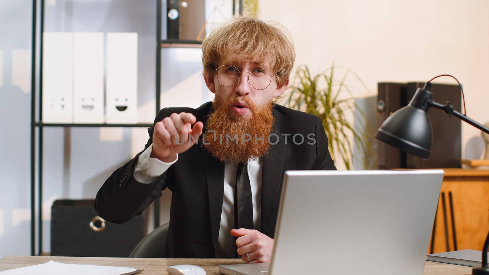 I choose you. Bearded businessman programmer software developer working on office laptop pointing to camera, looking with happy expression, making choice, showing direction. Young freelancer man