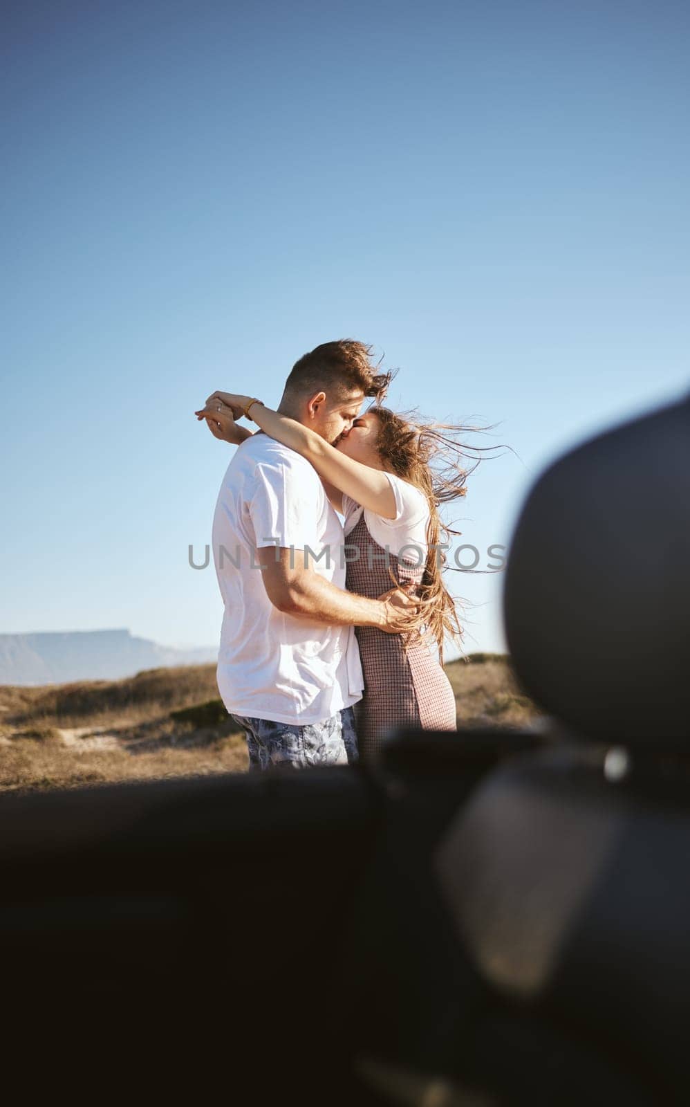 Road trip, travel and couple kiss and hug for holiday, vacation or outdoor adventure with blue sky mock up advertising or marketing. Love, romantic people with car by countryside road summer mockup by YuriArcurs