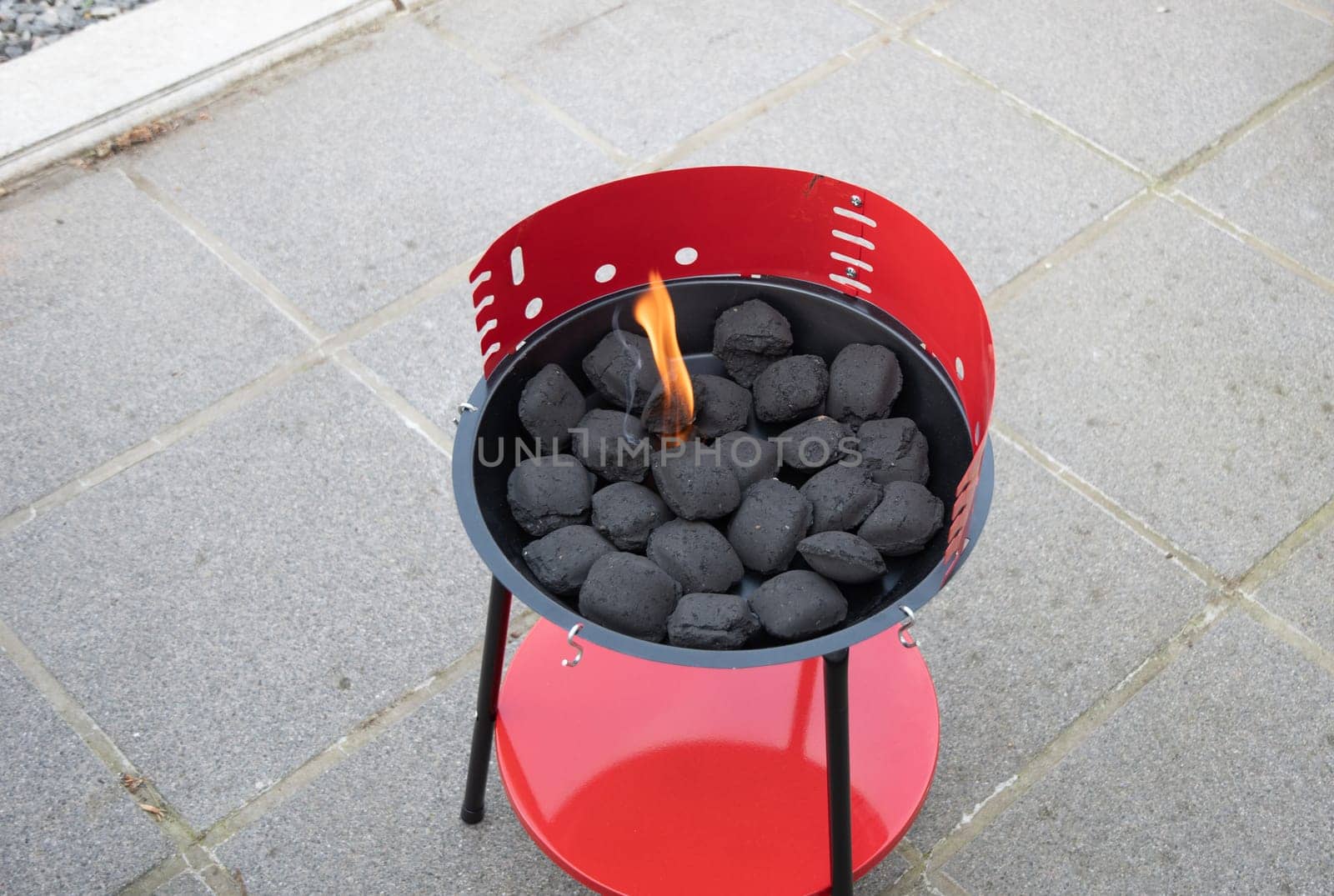 a man lights a fire with a lighter special charcoals for a barbecue a barbecue house on the terrace prepares a place for a barbecue. High quality photo