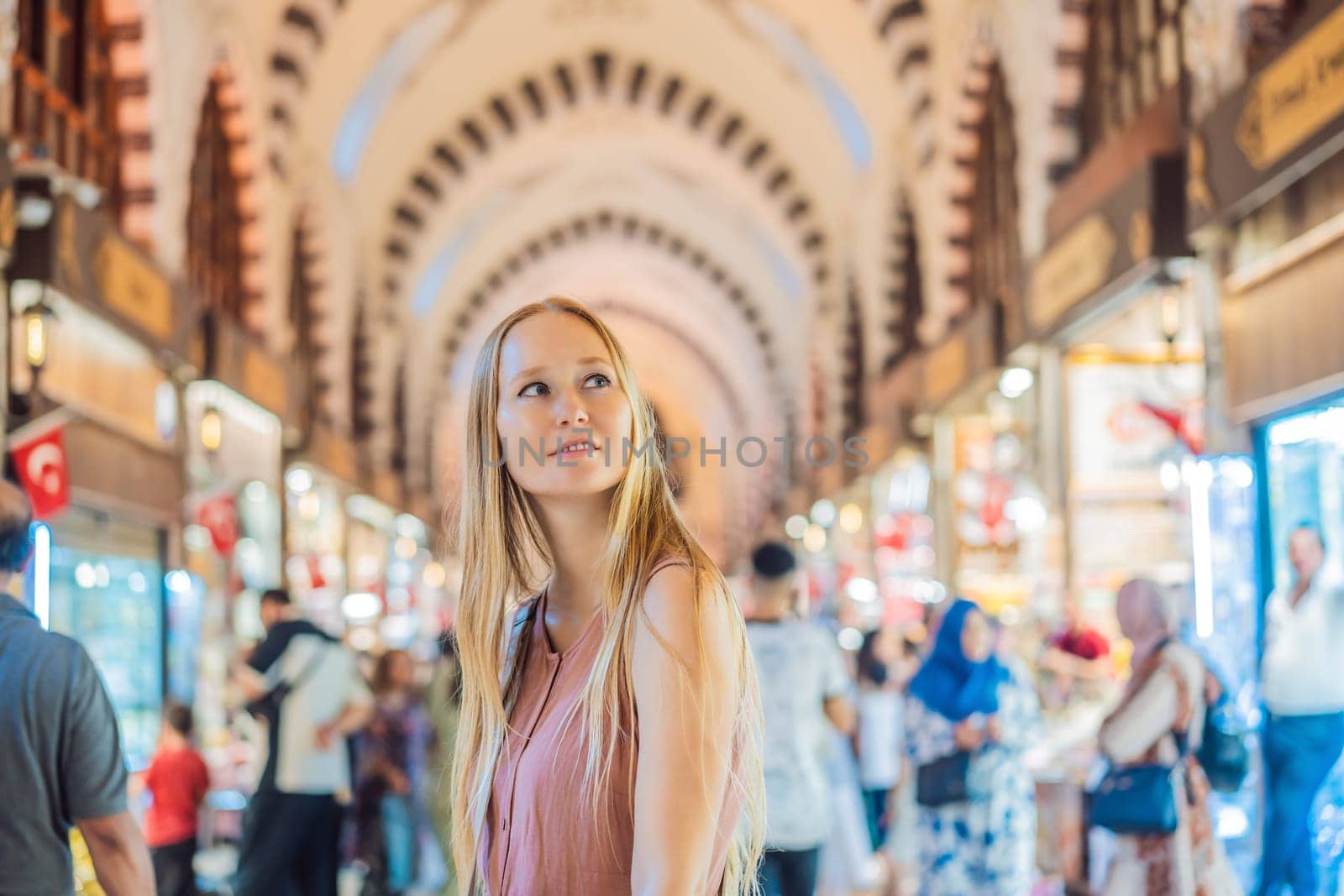 A tourist woman walks among the countless shops at the Grand Bazaar and Egyptian Bazaar in Istanbul. Shopping and travel in Turkey concept. Istanbul historical Egyptian Bazaar. Misir Carsisi, spice market. Turkiye.
