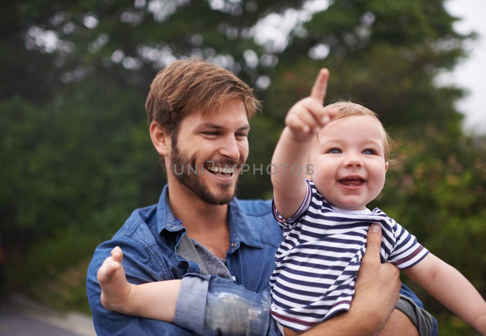 Look up there Daddy. young father and his baby boy enjoying a day outside. by YuriArcurs