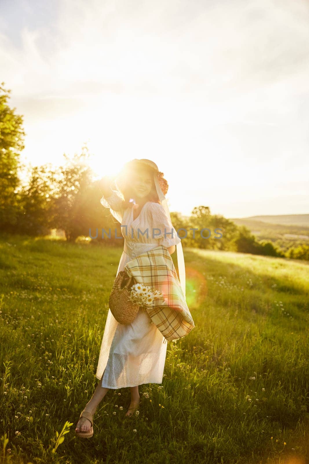 silhouette of a woman walking in the countryside in the glare from the setting sun. High quality photo