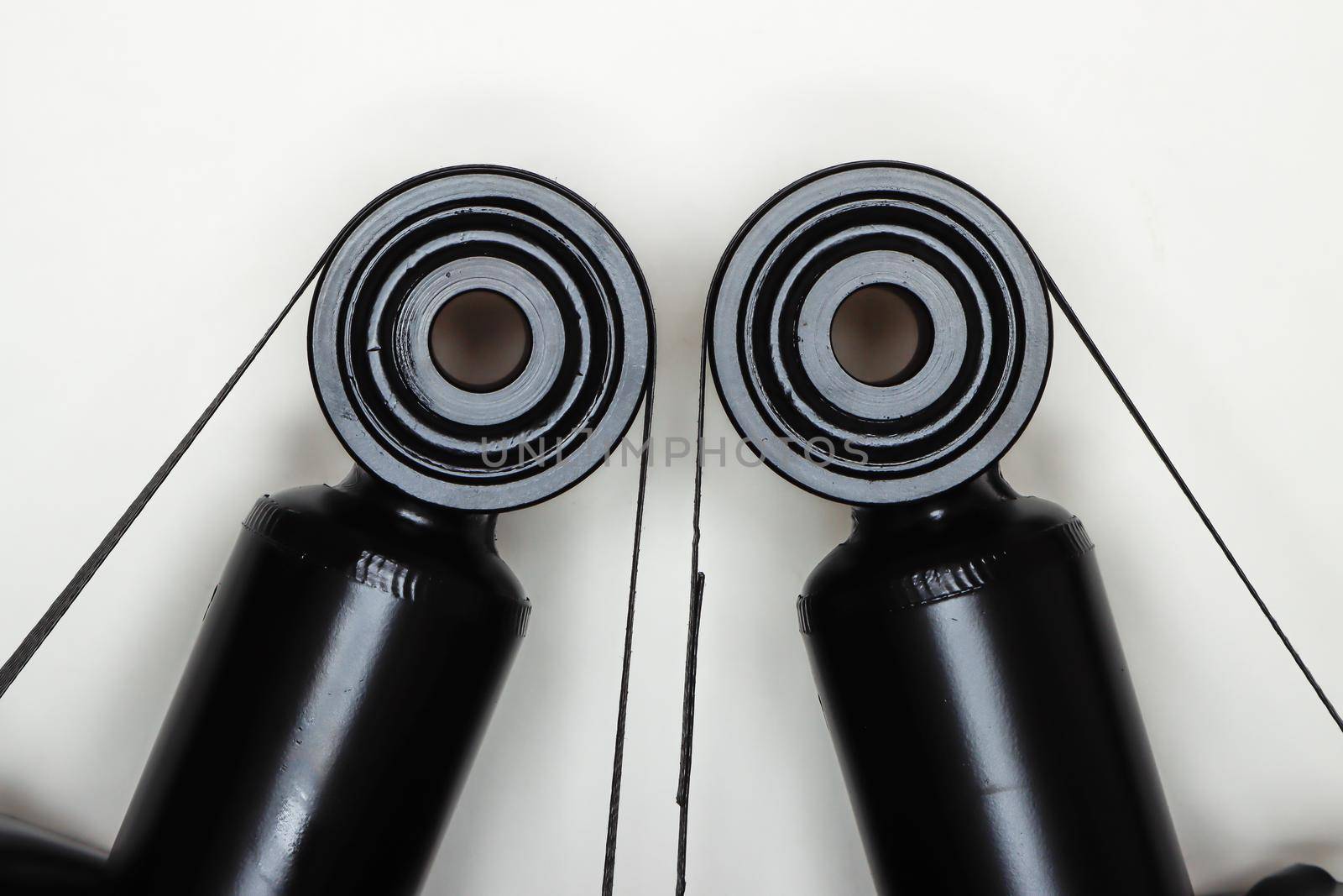 Two silent blocks on shock absorbers, parts for car repair. A set of spare parts for servicing the chassis of the vehicle. Details on white background, copy space available.