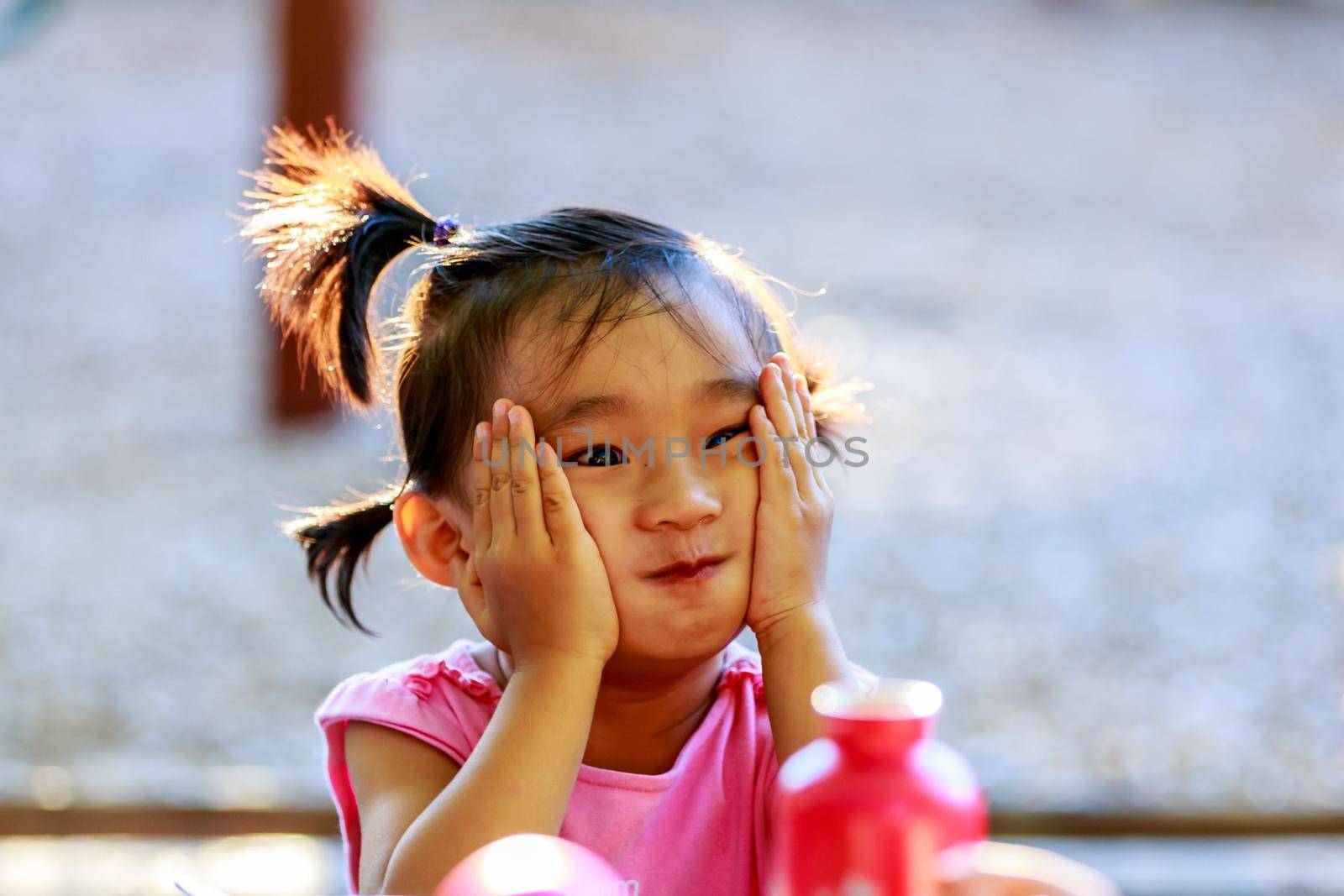 Adorable girl making faces in the park