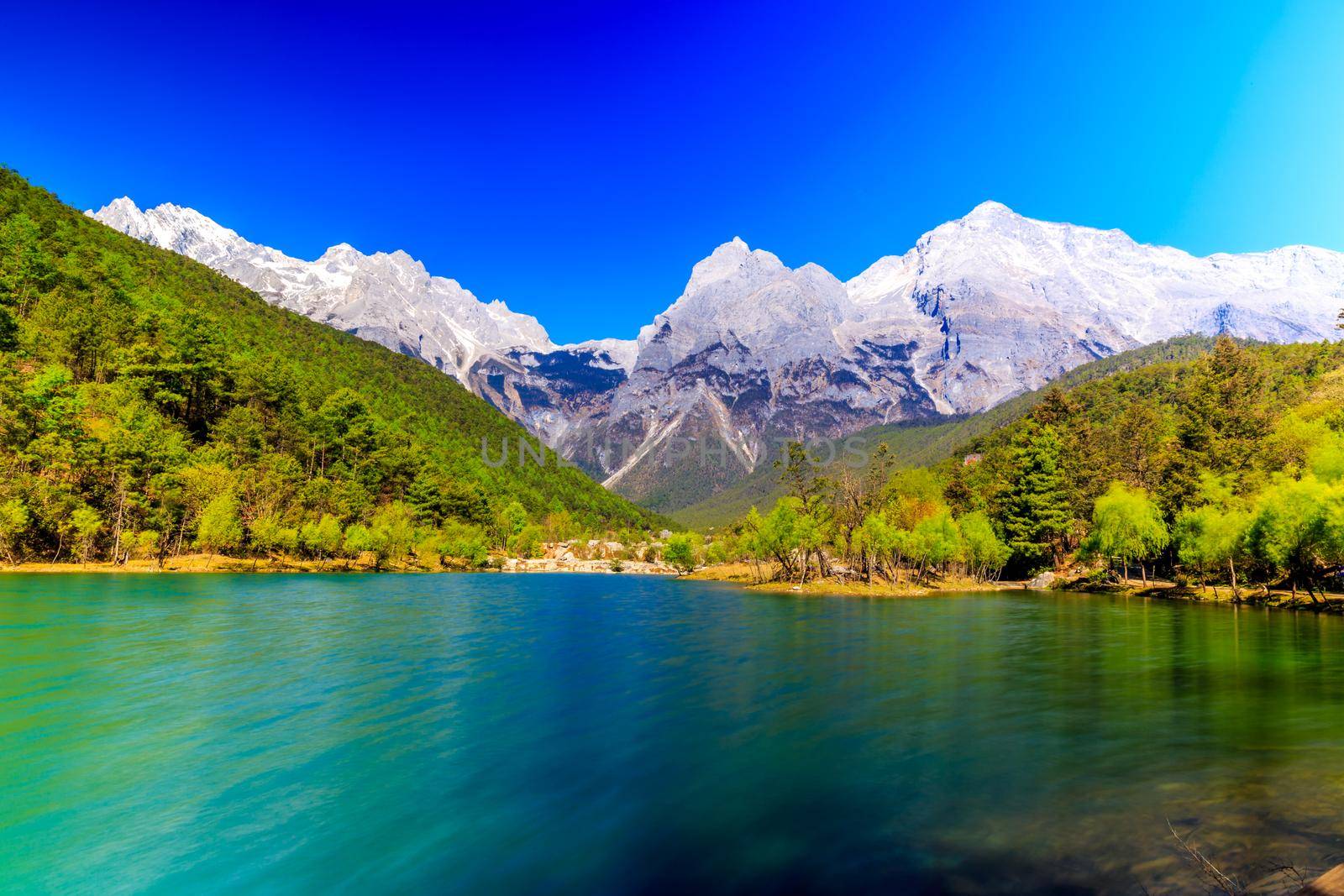 A view of a river and Jade Dragon Snow Mountain in Lijiang (Southwest China).