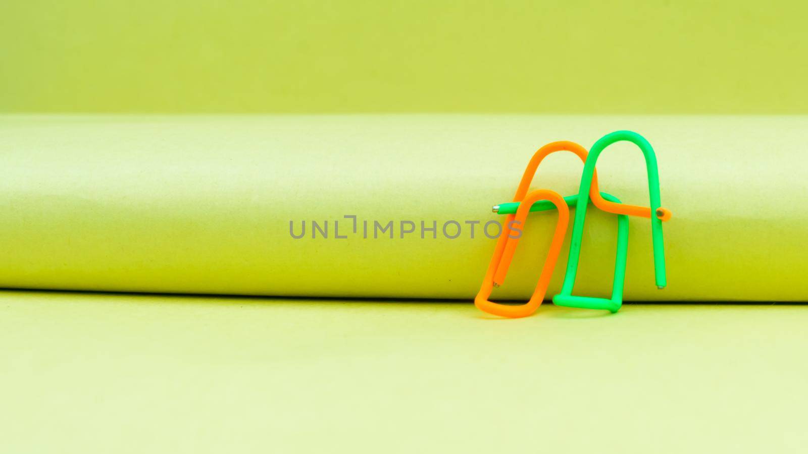 Happy couple sitting in a sweet pose. Abstract Human Figure of Paper Clip. Creative Photography. Still Life. Copy Space by sudiptabhowmick