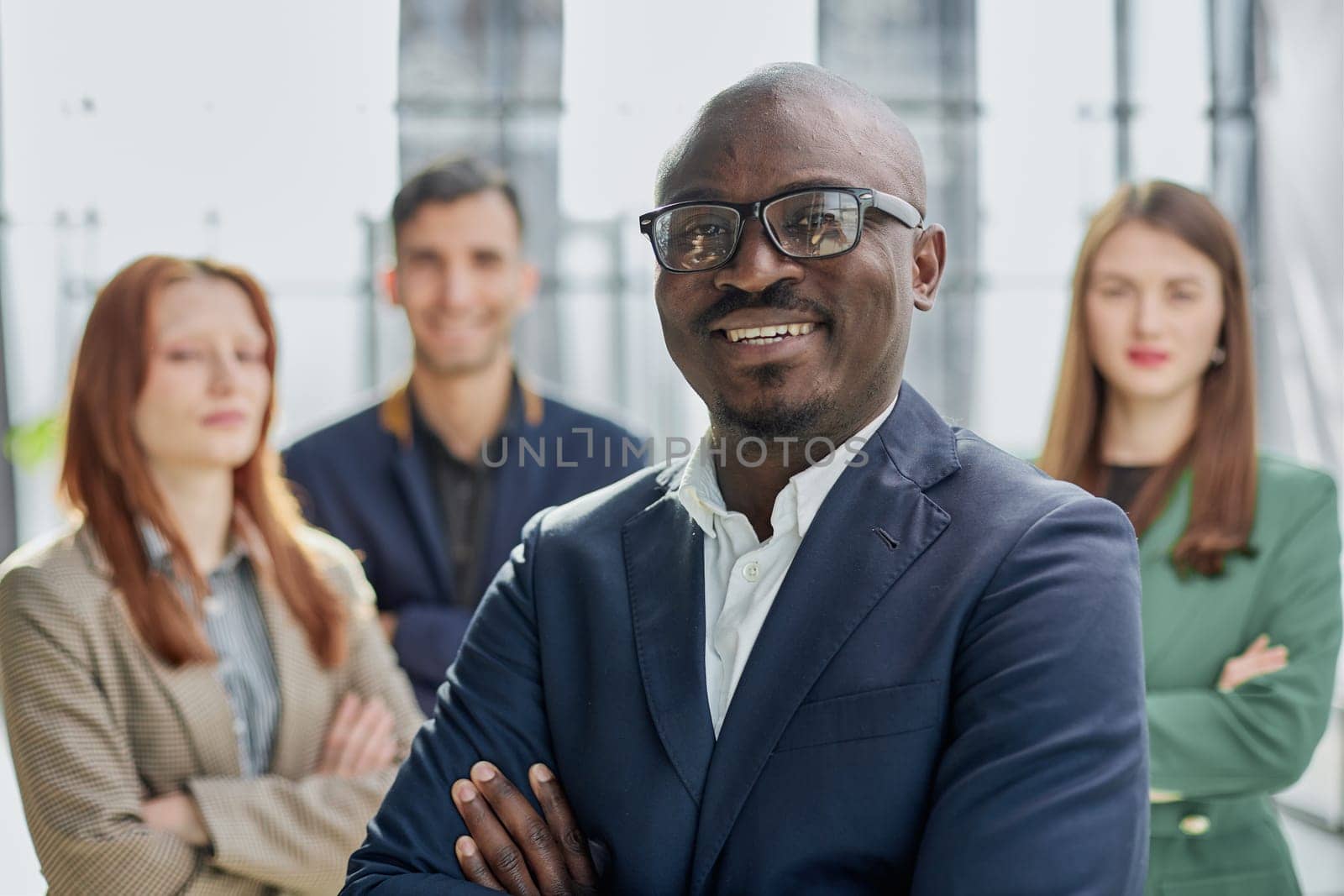 Modern young businessman in formal wear adjusting glasses looking at camera while standing in office