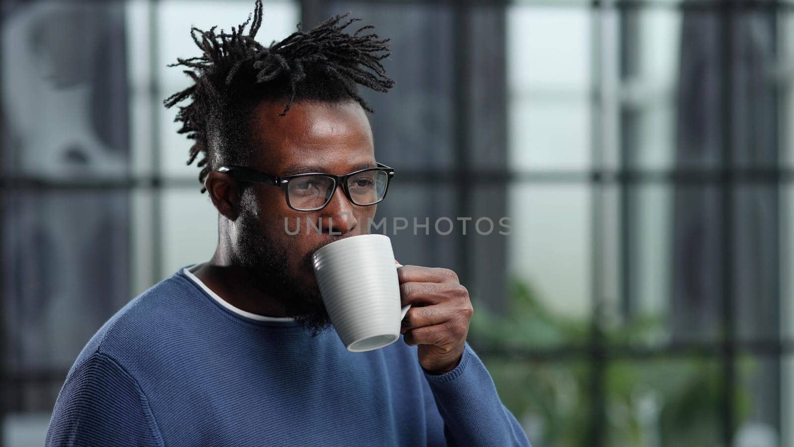 Portrait of a young businessman with a cup of coffee, in casual clothes