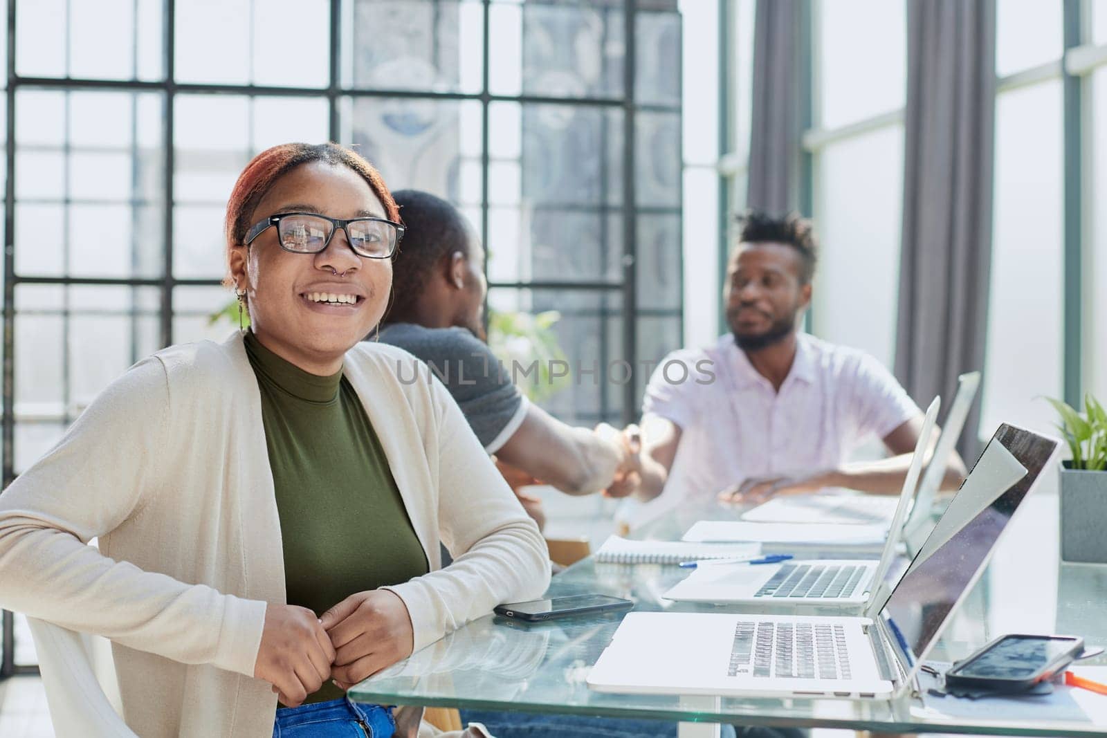 Portrait Of Businesswoman In Modern Open Plan Office With Business Team Working In Backgroun