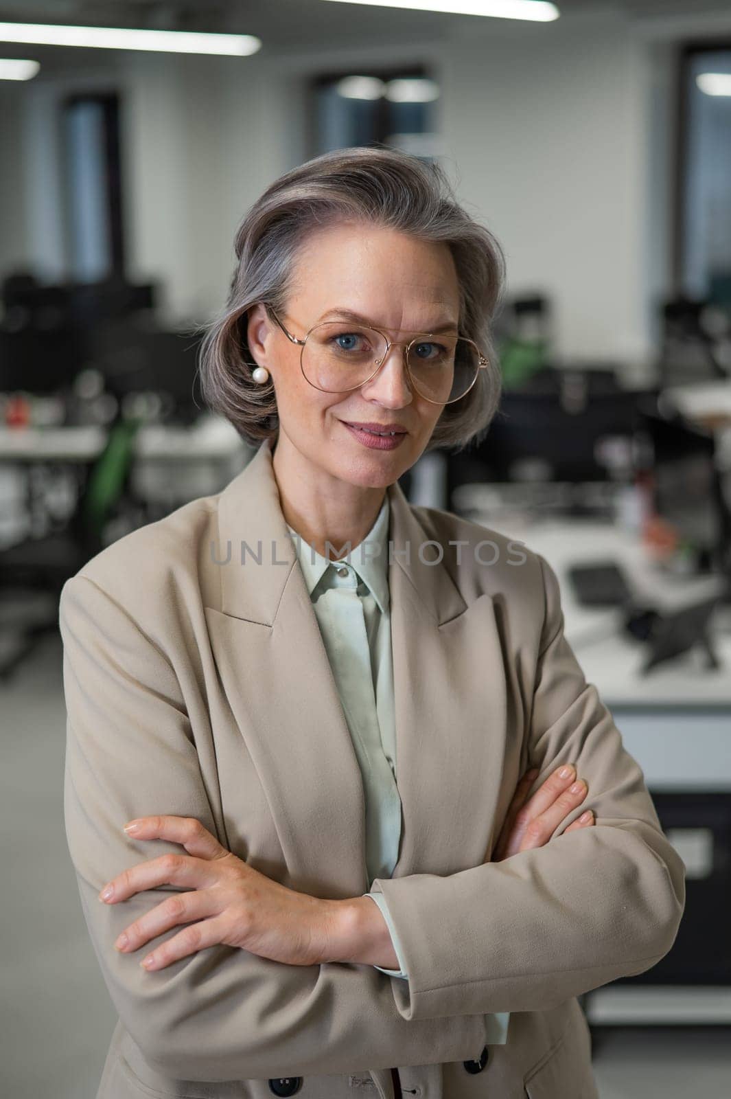 Portrait of an attractive mature caucasian woman with arms crossed on her chest in the office