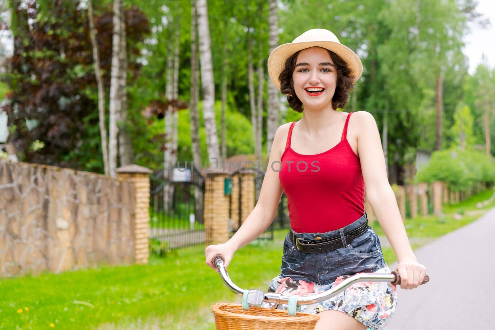 Portrait beautiful young girl in hat with bicycle on street in countryside by EkaterinaPereslavtseva