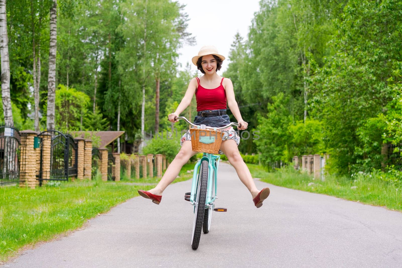 Portrait beautiful young girl in hat with bicycle on street in countryside by EkaterinaPereslavtseva