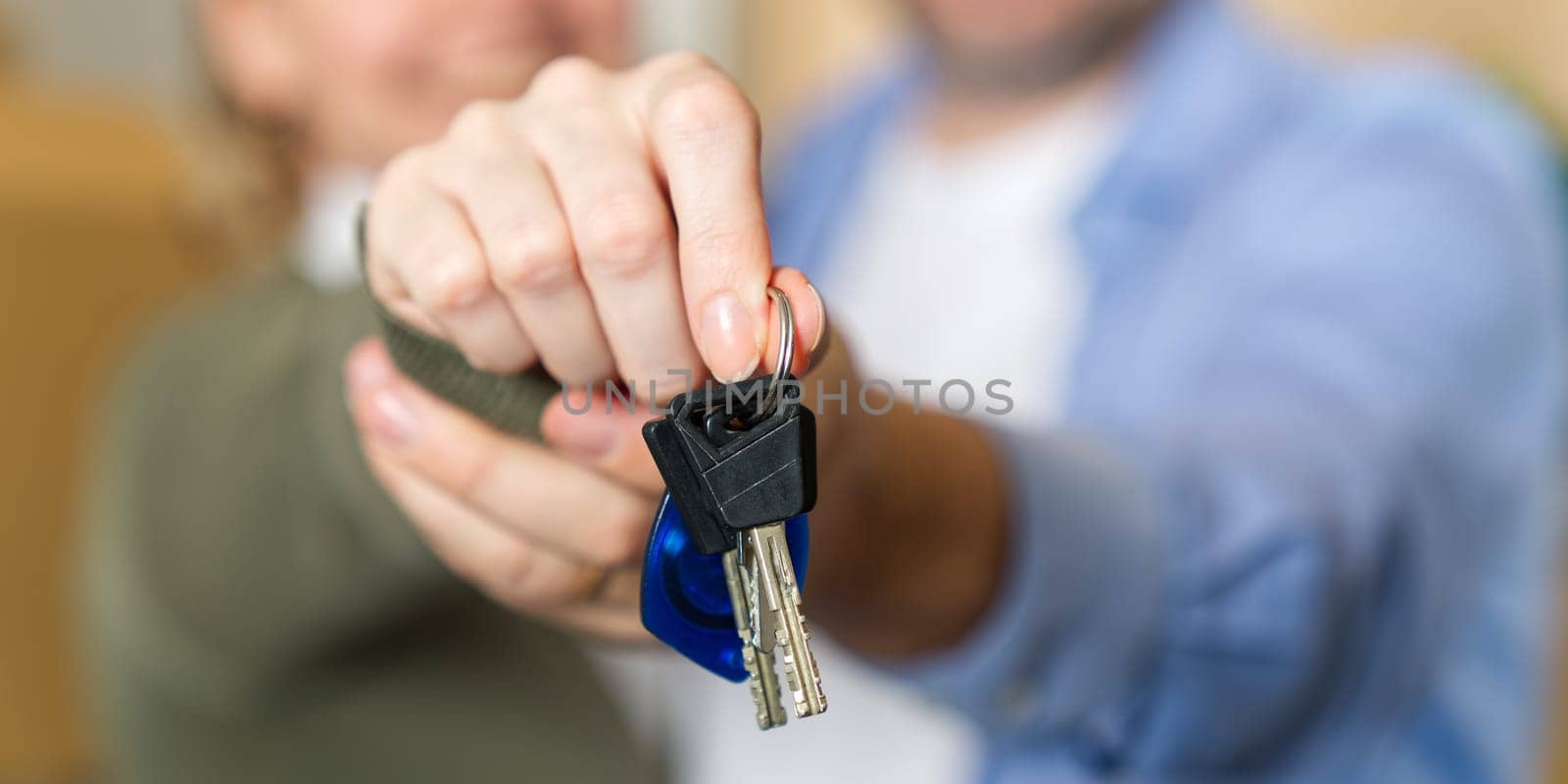 Couple showing keys to new apartment. real estate mortgage, loan concept. moving in new house by PhotoTime