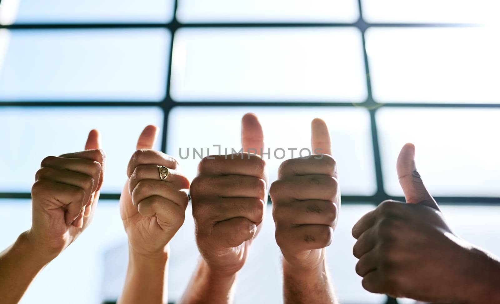 Succeeding is a team effort. a group of unrecognizable businesspeople gesturing thumbs up. by YuriArcurs