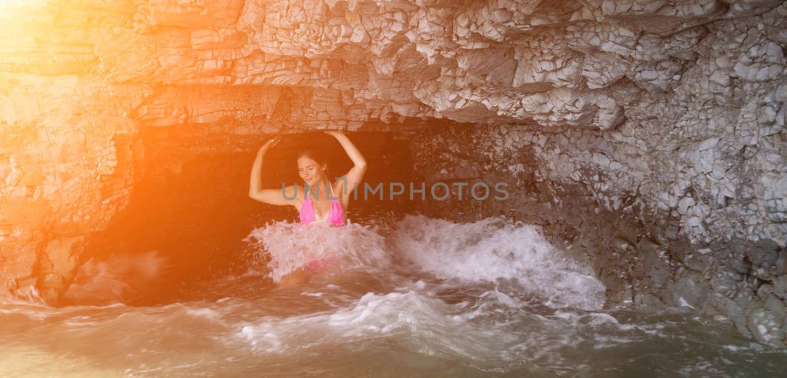 Woman travel sea. Young Happy woman in a long red dress posing on a beach near the sea on background of volcanic rocks, like in Iceland, sharing travel adventure journey