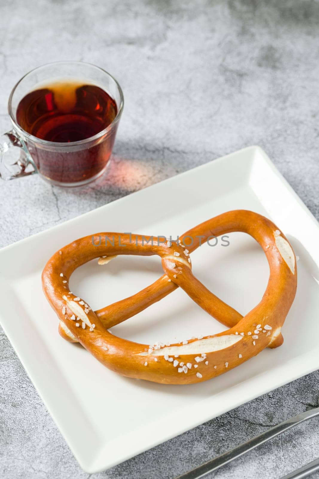 Pretzel in white porcelain plate on stone background