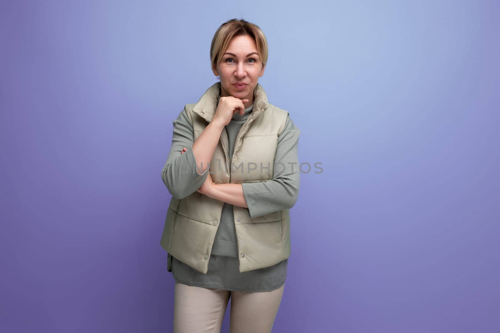 embarrassed blonde millennial woman in spring casual look on studio background with copy space.