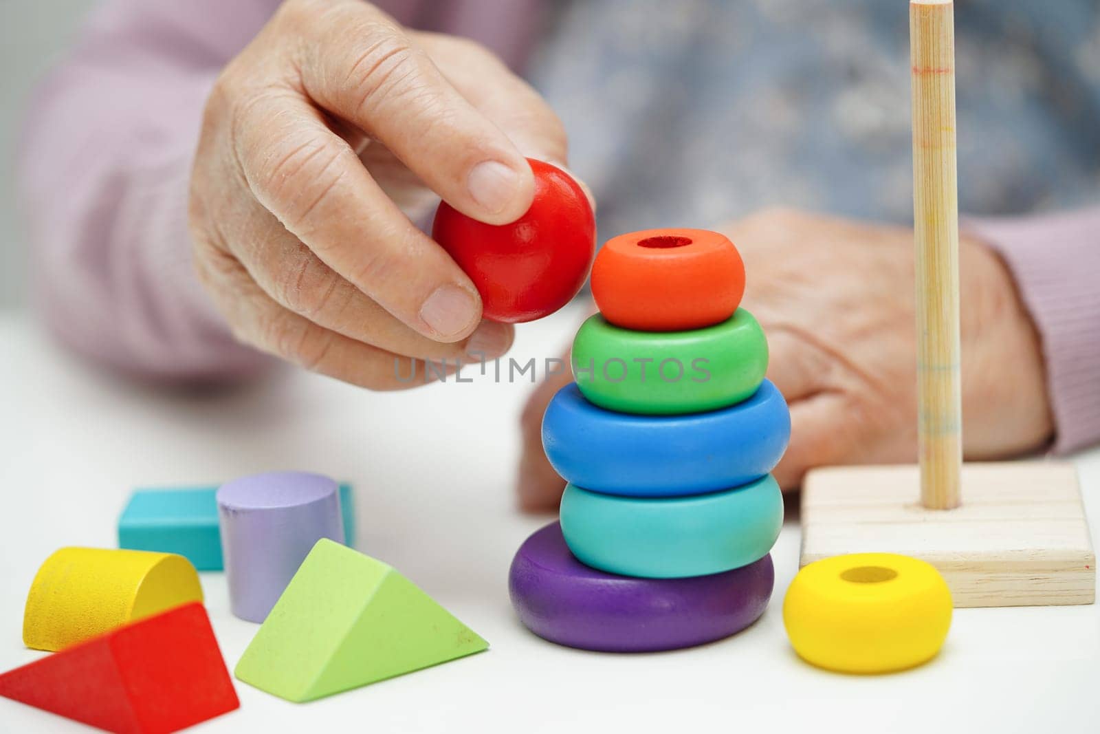 Asian elderly woman playing puzzles game to practice brain training for dementia prevention, Alzheimer disease. by sweettomato