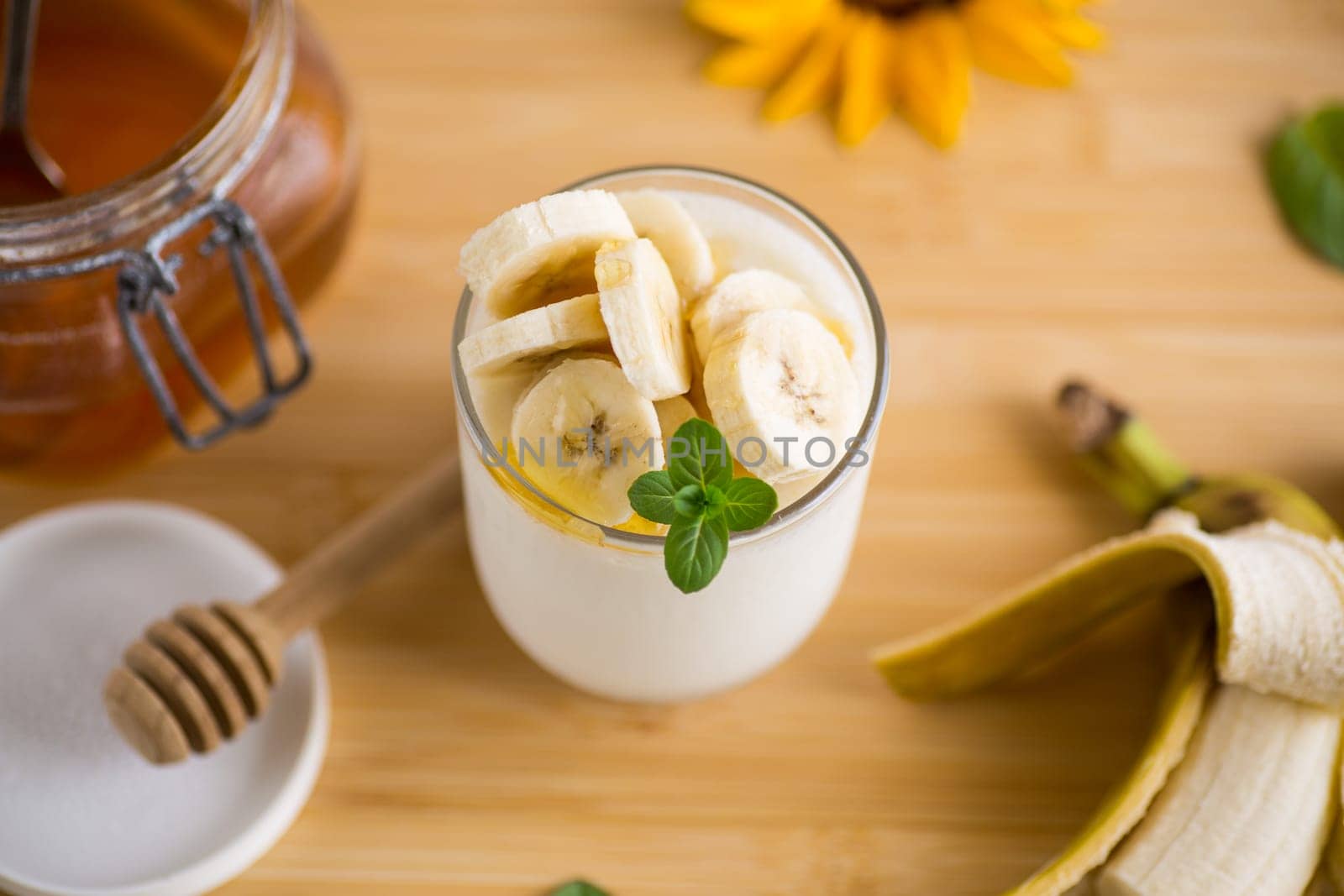 Sweet homemade yogurt with bananas and honey in a glass