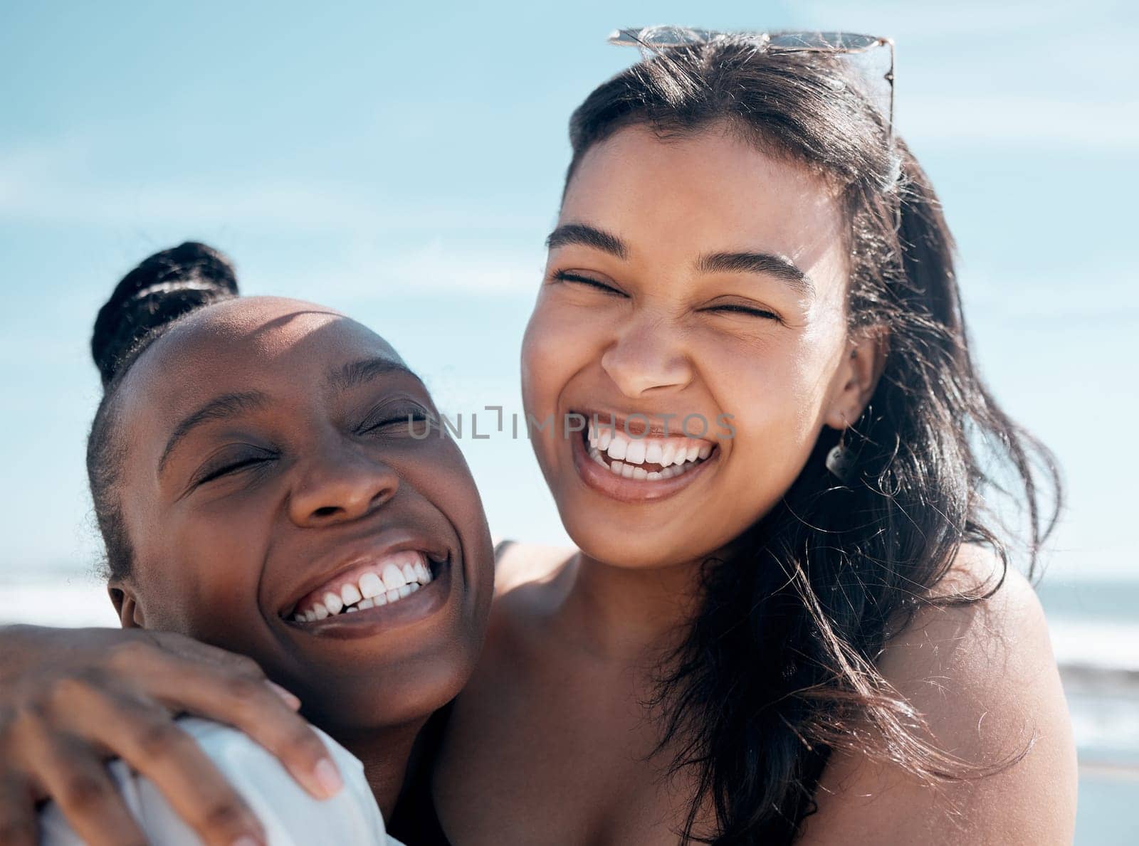 Woman, friends and hug with smile for beach day, summer vacation or travel together outdoors. Portrait of happy women laughing in joy for friendship, travel or fun holiday bonding by the ocean coast by YuriArcurs