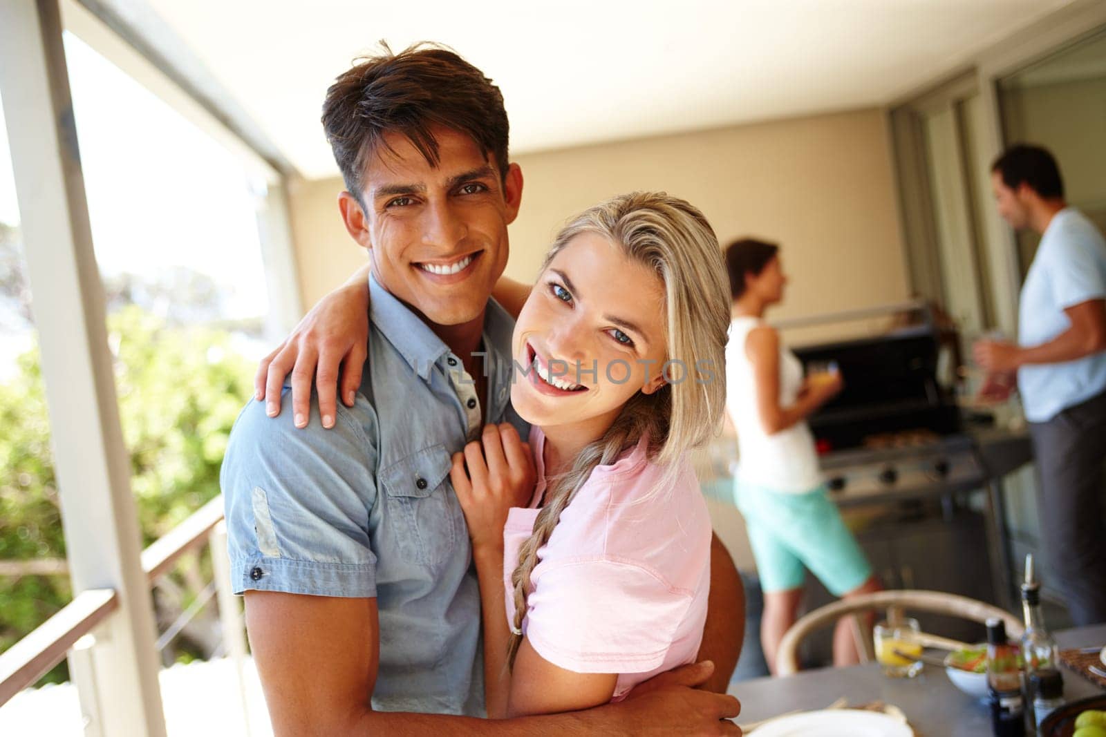 Happy hearts and big smiles. a young couple enjoying a barbeque at their friends place. by YuriArcurs