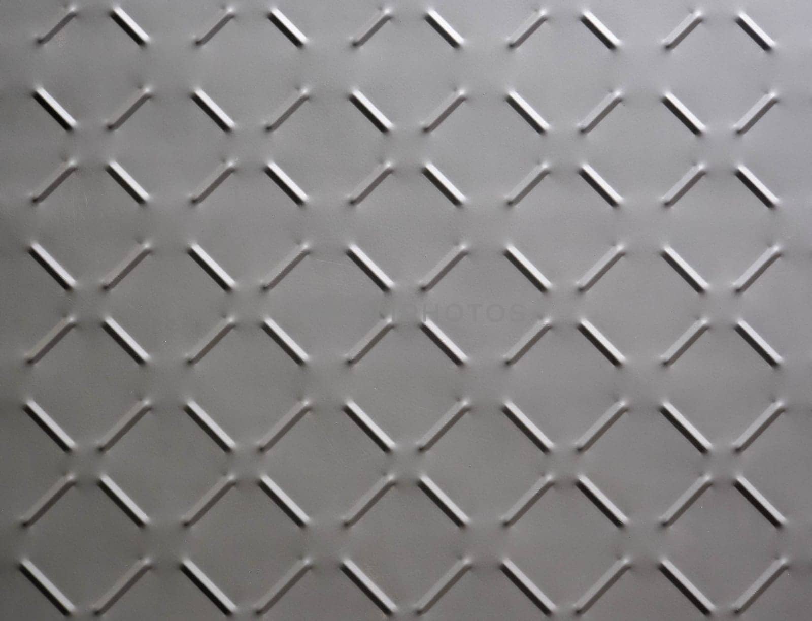 abstract background of old rusty metal plate with diamond pattern painted grey close up