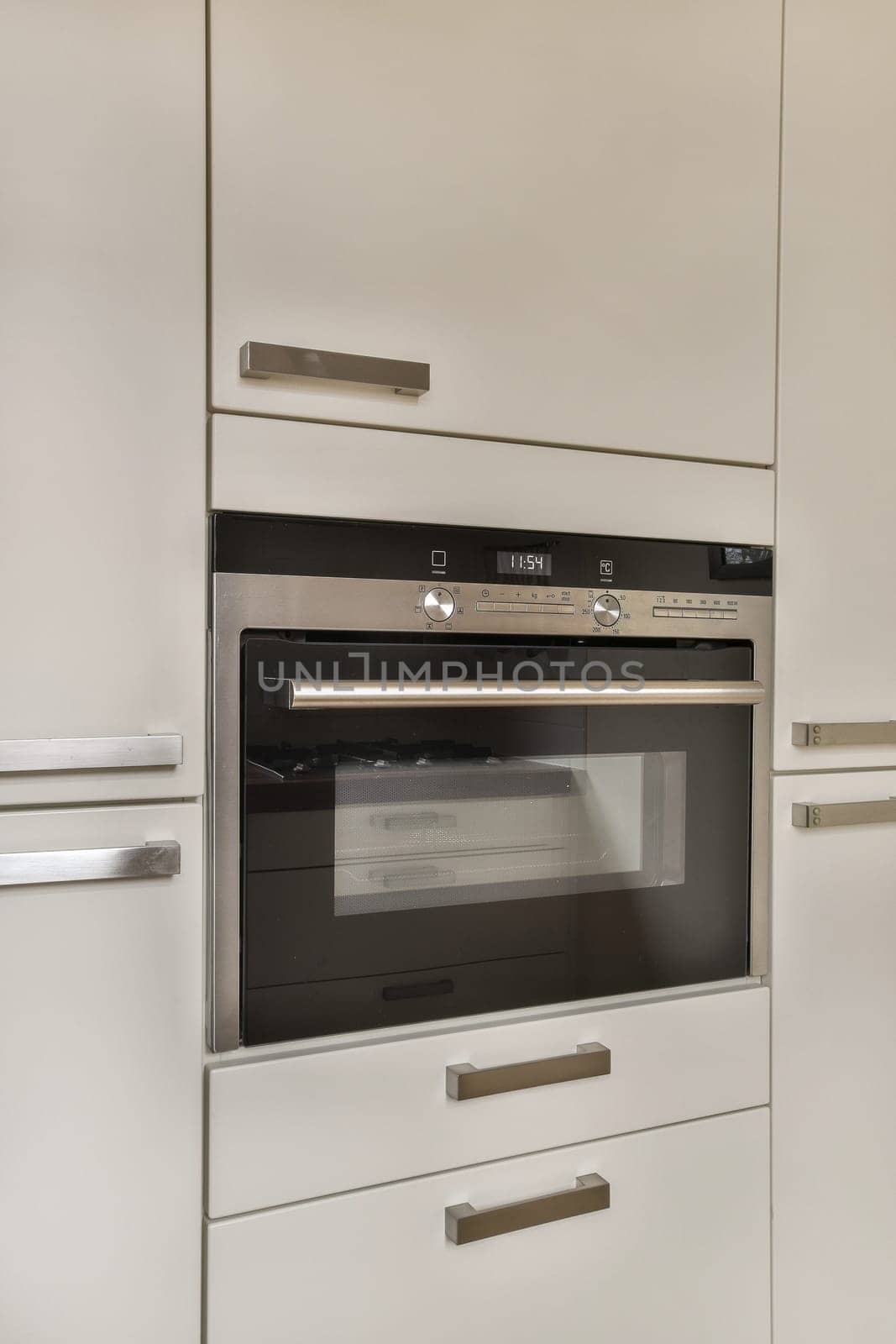 a kitchen with a oven and white cabinets by casamedia