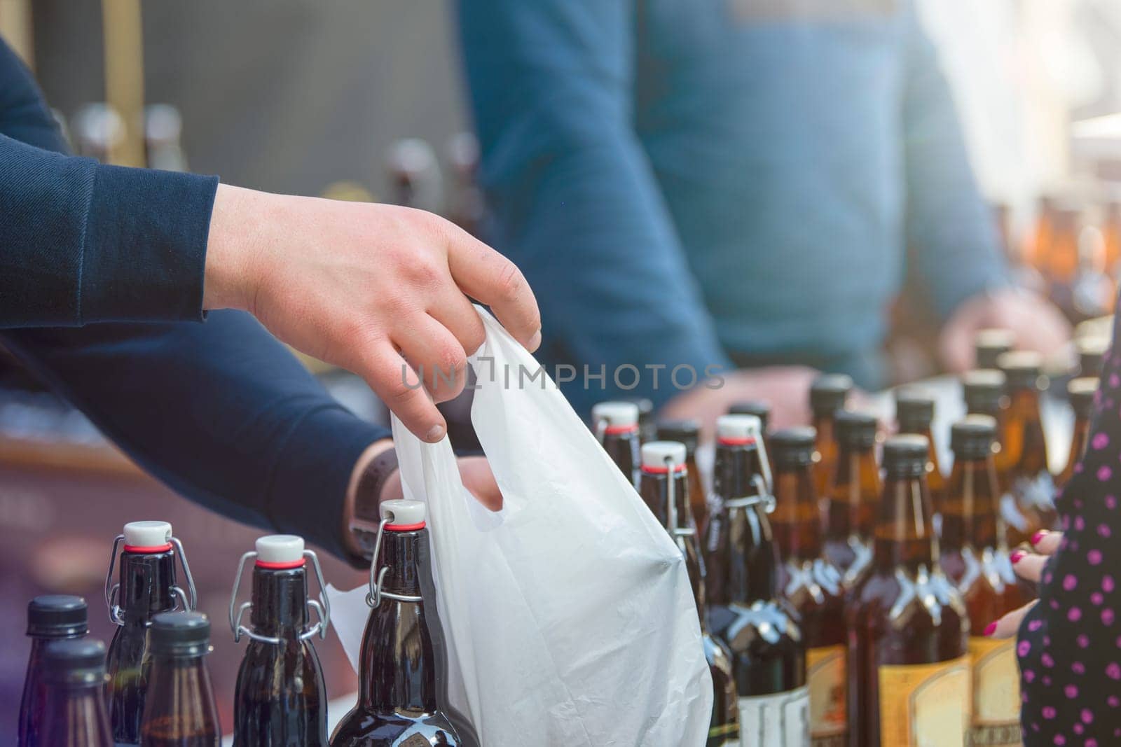 Craft beer vendor packaging beer bottles for a customer. The concept of a small business for the production of beer. Copy space. by SERSOL