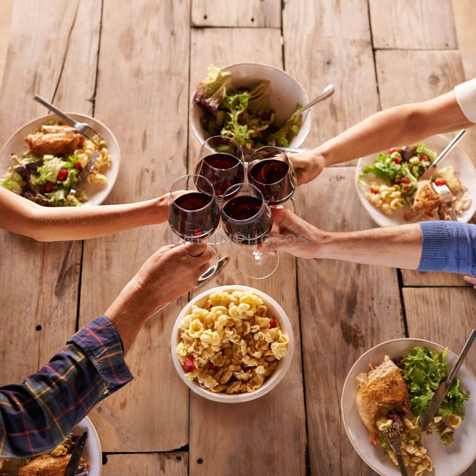 Hands, toast with wine glasses and food with cheer for celebration at lunch. Top view of event, congratulations or success and friends or family sharing a meal or dish together at table with drinks by YuriArcurs