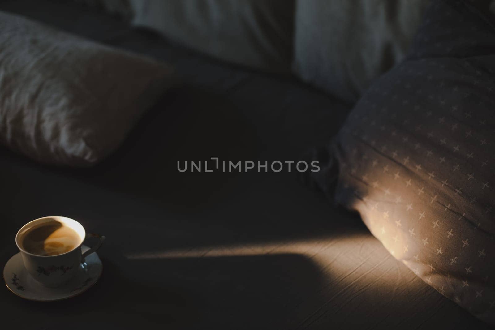 Coffee in a cozy interior home background, Lifestyle concept. Soft light of the rising sun came through the window to a cup of coffee on bed.