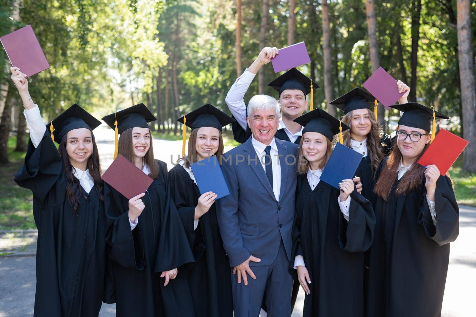 University professor and seven graduates rejoice at graduation. by mrwed54